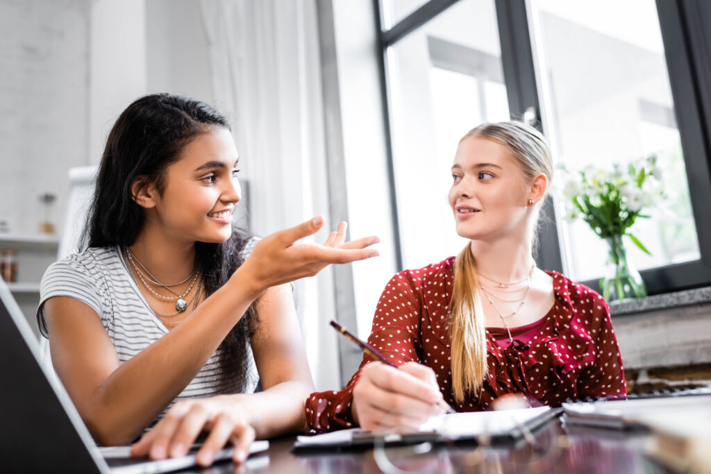 stock-photo-selective-focus-of-multicultural-friends-smiling-and-talking-in-apartment-1494959492