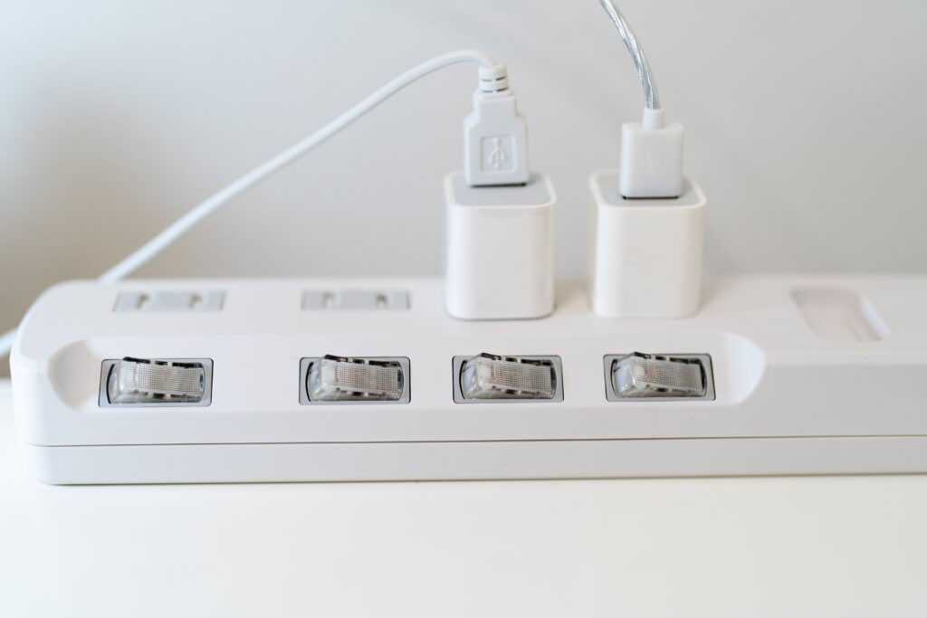 stock-photo-insert-the-charging-cable-into-the-multi-plug-place-a-white-power-strip-in-one-corner-of-the-desk-2149753125