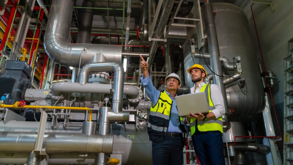 stock-photo-professional-male-electrical-engineer-in-safety-uniform-working-and-discussion-at-factory-site-2422033785