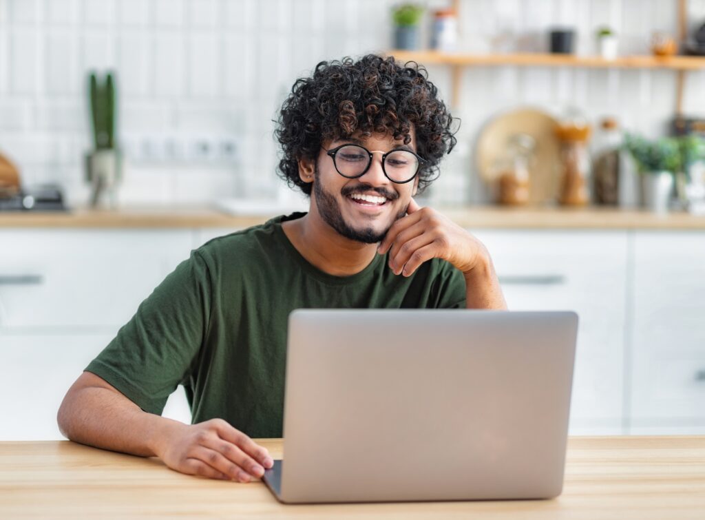 stock-photo-portrait-of-successful-freelancer-or-student-working-on-new-project-smiling-young-indian-man-using-2441476611
