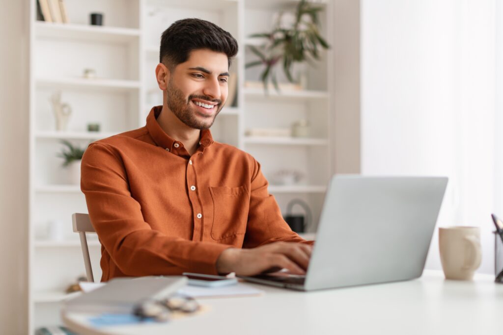 stock-photo-portrait-of-smiling-middle-eastern-male-manager-working-on-laptop-computer-in-modern-office-2140128359