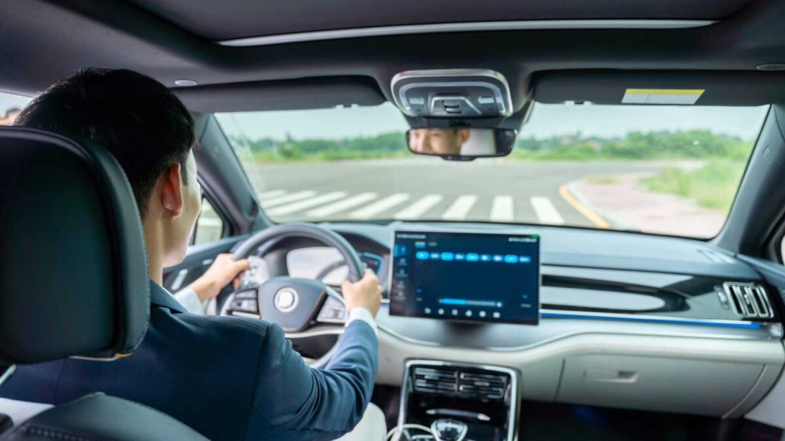 stock-photo-a-man-driving-inside-of-electric-car-front-view-of-the-road-electric-car-ev-car-ev-vehicle-2203990117