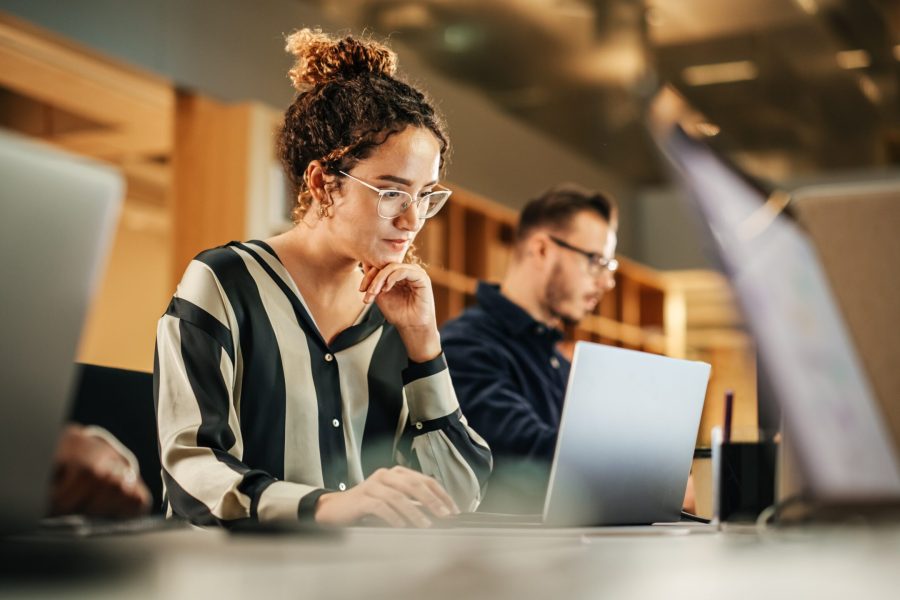 stock-photo-portrait-of-enthusiastic-hispanic-young-woman-working-on-computer-in-a-modern-bright-office-2242410029