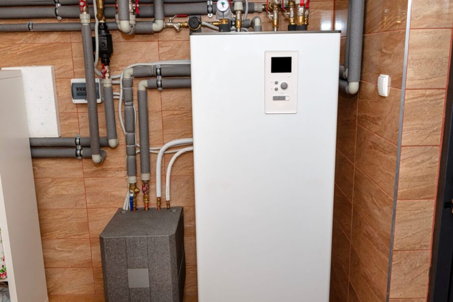 stock-photo-a-modern-air-heat-pump-installed-in-the-home-s-boiler-room-visible-plastic-pipes-and-valves-2389322725